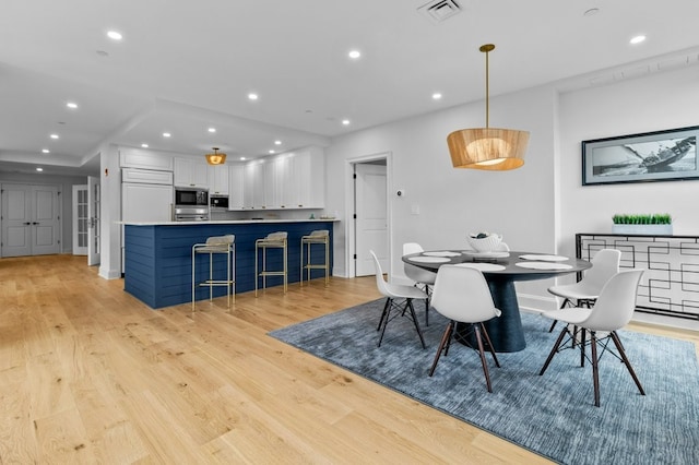 dining area featuring light wood finished floors, visible vents, and recessed lighting