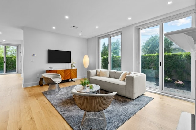 living area with a wealth of natural light, visible vents, light wood finished floors, and recessed lighting