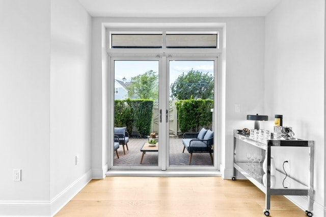 doorway featuring wood finished floors and baseboards