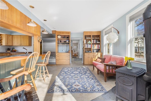 kitchen featuring pendant lighting, stainless steel built in refrigerator, a sink, and open shelves