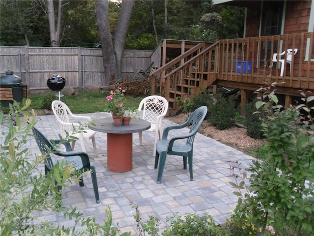 view of patio / terrace featuring a deck, stairway, fence, and a grill