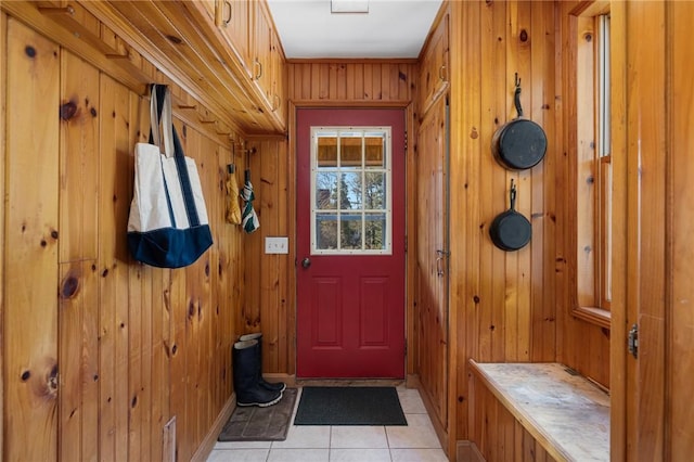 mudroom with light tile patterned floors and wooden walls