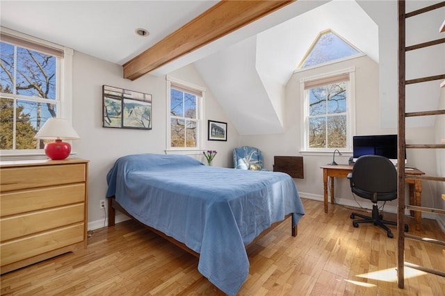 bedroom with lofted ceiling with beams, multiple windows, and light wood-style floors