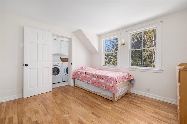 bedroom with baseboards, light wood-style flooring, and washer and dryer