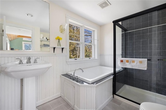 bathroom featuring visible vents, a stall shower, wainscoting, tile patterned flooring, and a bath