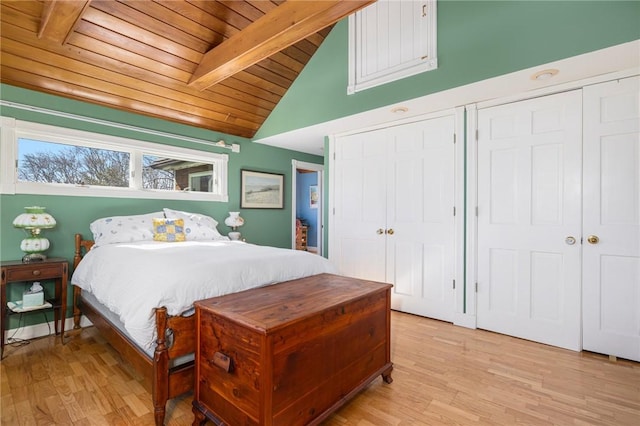 bedroom featuring multiple closets, wooden ceiling, lofted ceiling with beams, and light wood finished floors