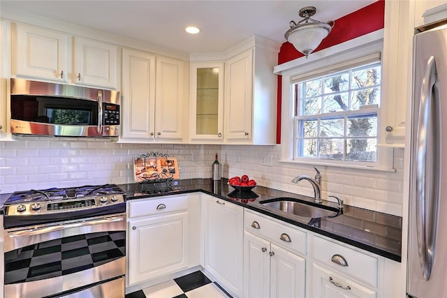 kitchen featuring stainless steel appliances, white cabinetry, and a sink