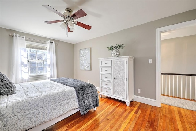 bedroom with light wood-style floors, baseboards, and a ceiling fan