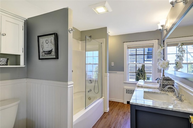 full bathroom featuring shower / tub combination, toilet, a sink, wainscoting, and radiator heating unit