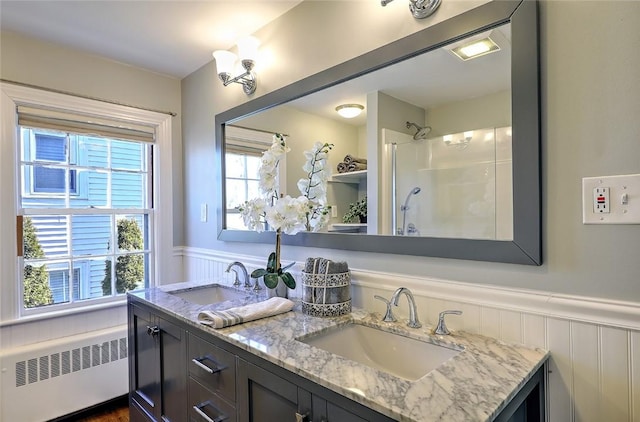 full bath with a shower, wainscoting, a sink, and radiator