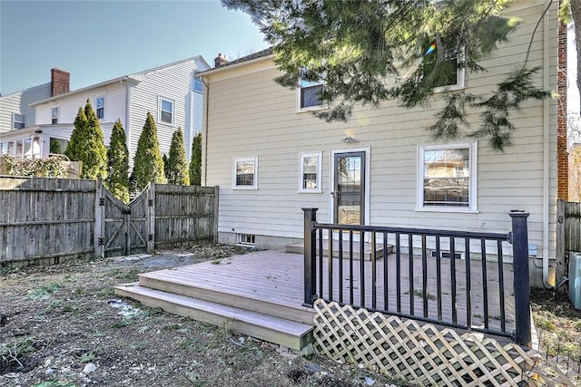 back of house featuring a gate, fence, and a deck