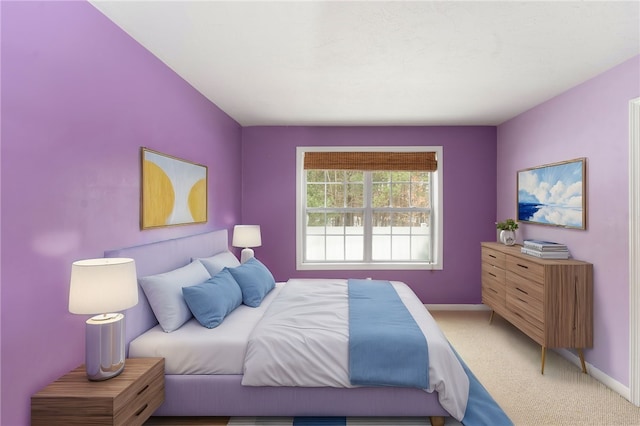 bedroom with light carpet and baseboards