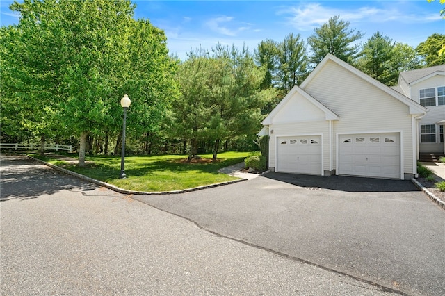 view of front facade featuring a garage, aphalt driveway, and a front lawn