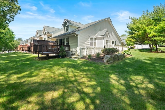 view of property exterior featuring a lawn, cooling unit, and a wooden deck