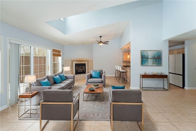 living room with a tile fireplace, baseboards, and light tile patterned floors