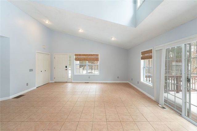 unfurnished room featuring high vaulted ceiling, light tile patterned flooring, visible vents, and baseboards