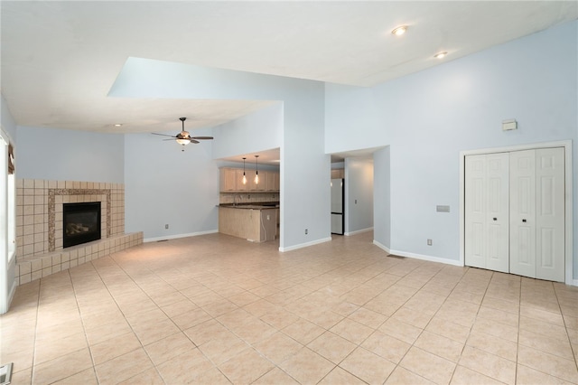 unfurnished living room with visible vents, a fireplace, baseboards, and a ceiling fan