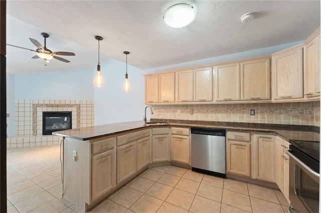 kitchen with stainless steel appliances, decorative backsplash, light brown cabinets, a sink, and a peninsula