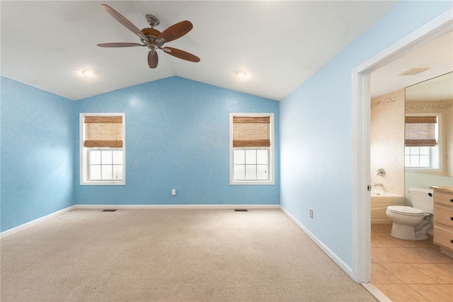 unfurnished bedroom with visible vents, baseboards, vaulted ceiling, carpet, and ensuite bath