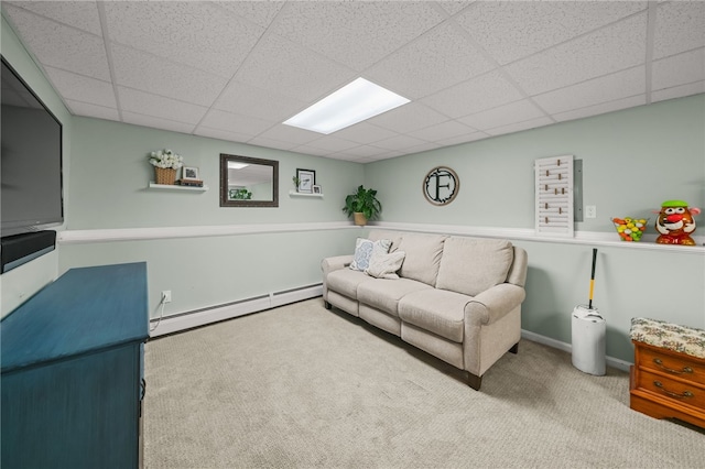 carpeted living area with baseboard heating, a paneled ceiling, and baseboards