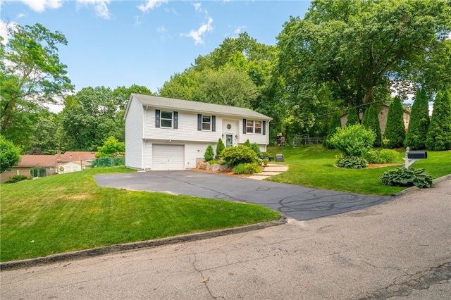 split foyer home with aphalt driveway, an attached garage, and a front lawn