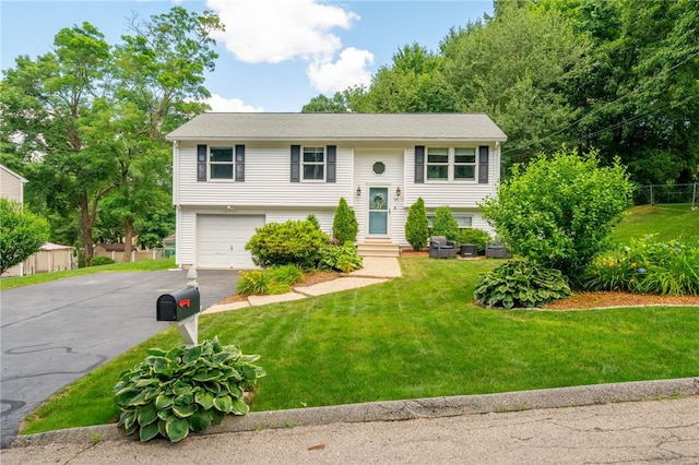 split foyer home with entry steps, aphalt driveway, a front lawn, and an attached garage