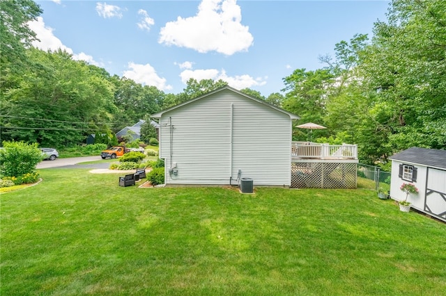 exterior space with an outbuilding, a shed, a lawn, and a wooden deck