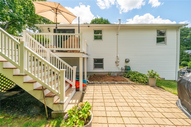 rear view of property with stairs, a patio, and a wooden deck