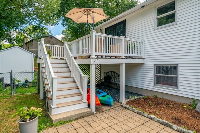 exterior space with stairs, a wooden deck, fence, and a gate