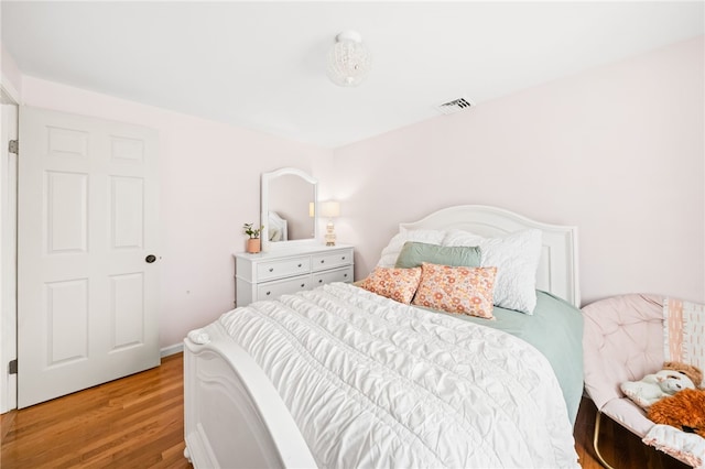 bedroom featuring wood finished floors and visible vents