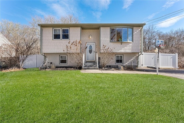 split foyer home with entry steps, a front lawn, fence, and a gate