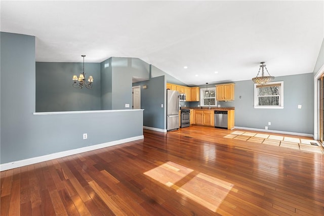 unfurnished living room with lofted ceiling, baseboards, a notable chandelier, and light wood-style floors