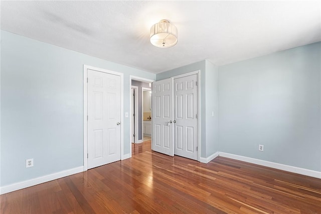 unfurnished bedroom featuring wood finished floors and baseboards