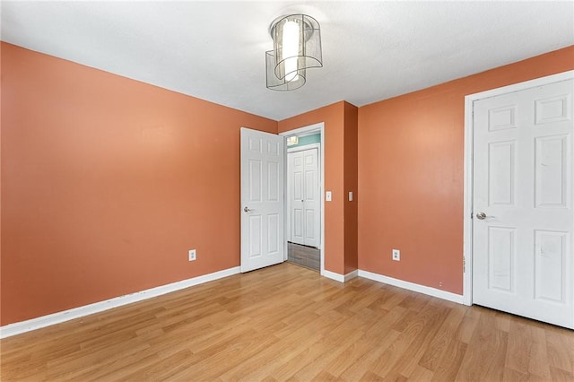 unfurnished bedroom with baseboards and light wood-style floors