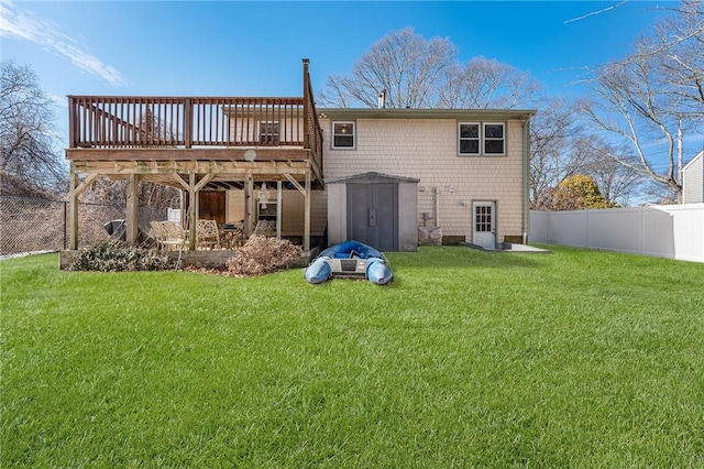 rear view of house featuring a fenced backyard, a yard, and a storage shed