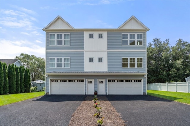 view of front of property featuring driveway, an attached garage, and fence