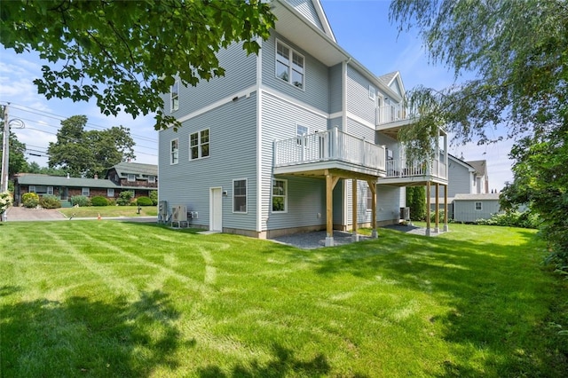 back of house with a lawn, cooling unit, and a balcony