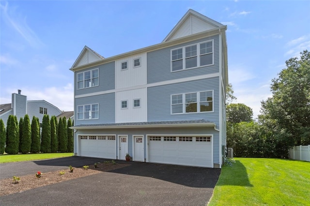 view of front of house featuring driveway, an attached garage, and a front lawn