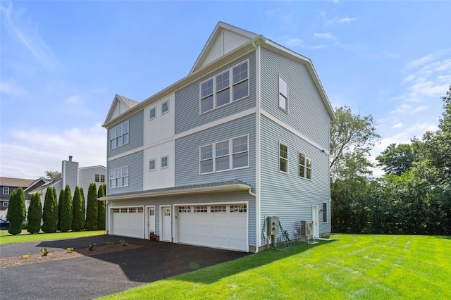 view of side of property featuring aphalt driveway, a lawn, and an attached garage