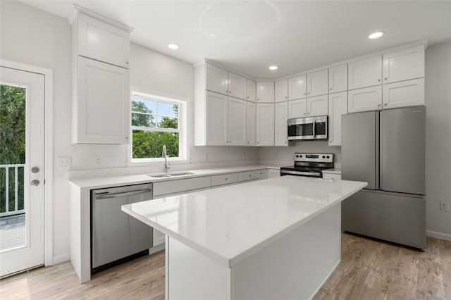 kitchen featuring a sink, light wood-style floors, appliances with stainless steel finishes, and light countertops