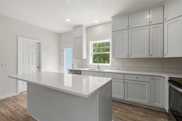 kitchen featuring electric range, light countertops, dark wood-type flooring, and a sink