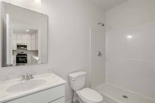 bathroom featuring vanity, toilet, and a shower