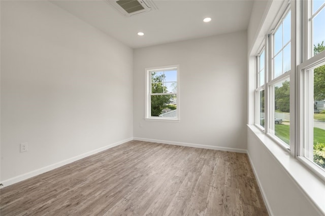 spare room with visible vents, recessed lighting, baseboards, and wood finished floors