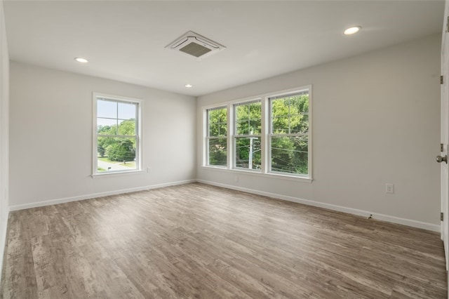 spare room featuring recessed lighting, baseboards, and wood finished floors