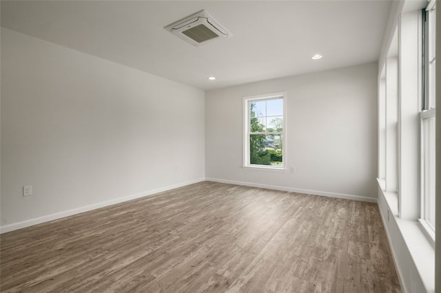 spare room with recessed lighting, baseboards, and wood finished floors