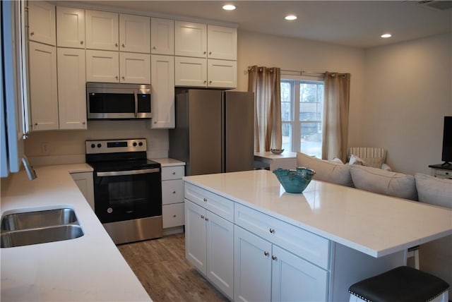 kitchen featuring recessed lighting, stainless steel appliances, light countertops, dark wood-type flooring, and open floor plan