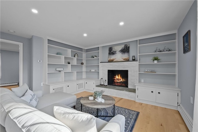 living area with a brick fireplace, a baseboard radiator, baseboard heating, light wood-style floors, and recessed lighting