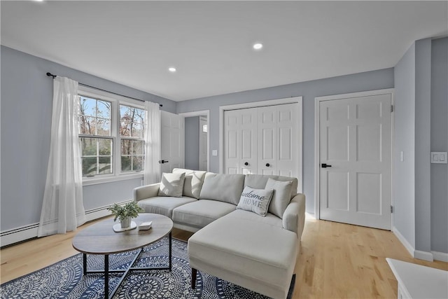 living room with baseboards, a baseboard heating unit, recessed lighting, and light wood-style floors