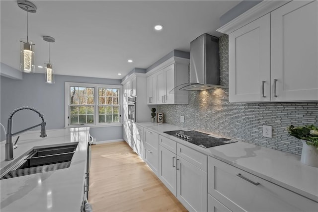 kitchen featuring black electric stovetop, tasteful backsplash, a sink, wall chimney range hood, and oven