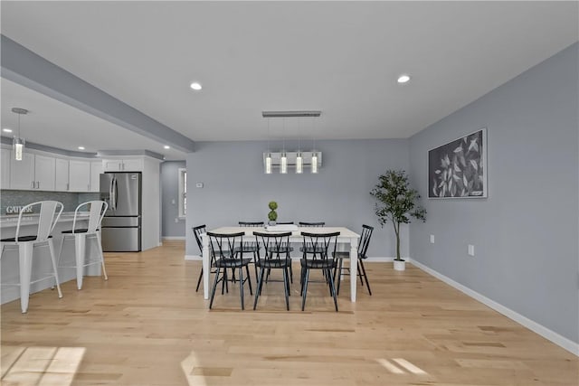 dining room with light wood-style flooring, baseboards, and recessed lighting